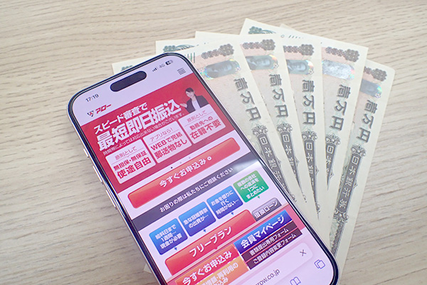 アローの公式ホームページを表示させたスマホとお金
