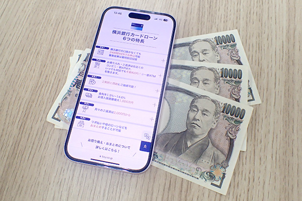 横浜銀行カードローンの公式ホームページを表示させたスマホとお金